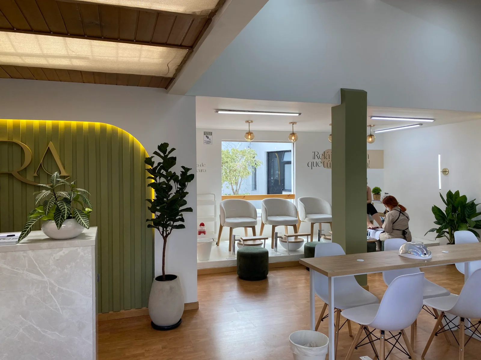 Interior del salón Aura Nails Care en Cedritos — recepción y área de trabajo con decoración natural en tonos sage y madera