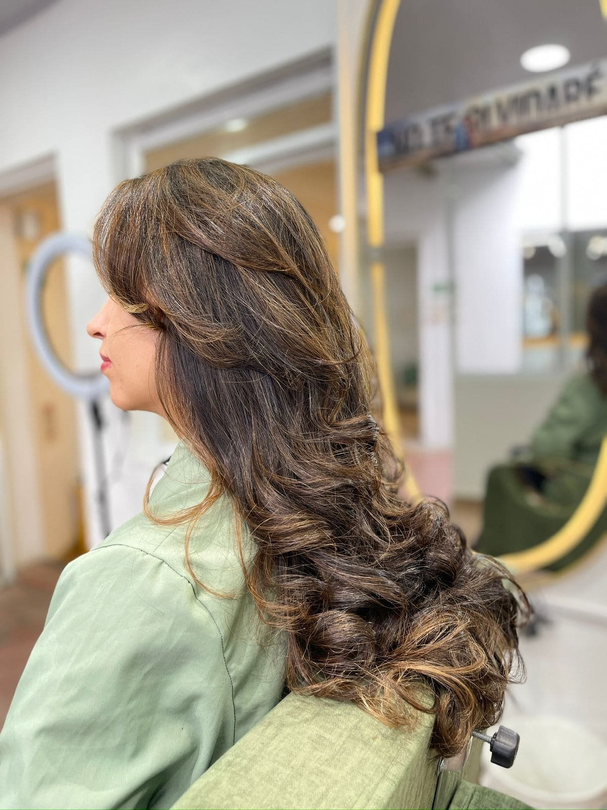 Peinado con ondas y reflejos castaños en Aura Nails Care — resultado profesional de salón